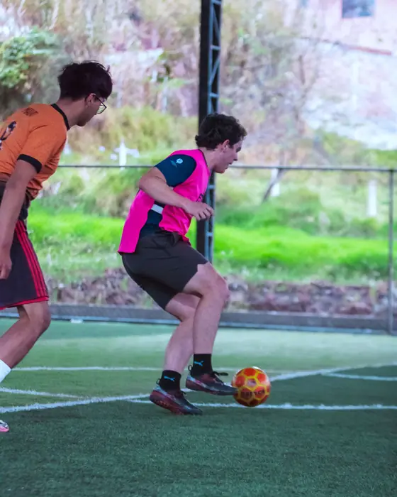 Jugador de pechera rosada controlando el balón