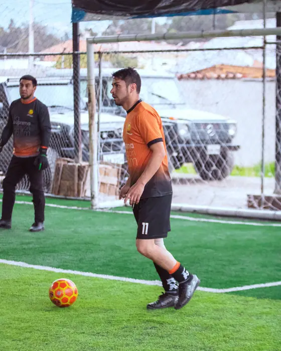Jugador número 11 de naranja junto al arco